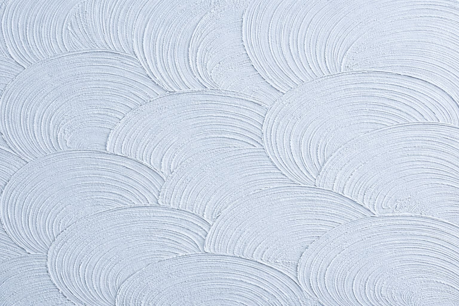 Close-up of sand swirl drywall texture with overlapping troweled arcs on an off-white wall in Washington State.
