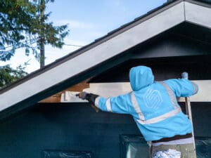 Shanco painter rolling exterior gable trim on a home in the Seattle area, Washington